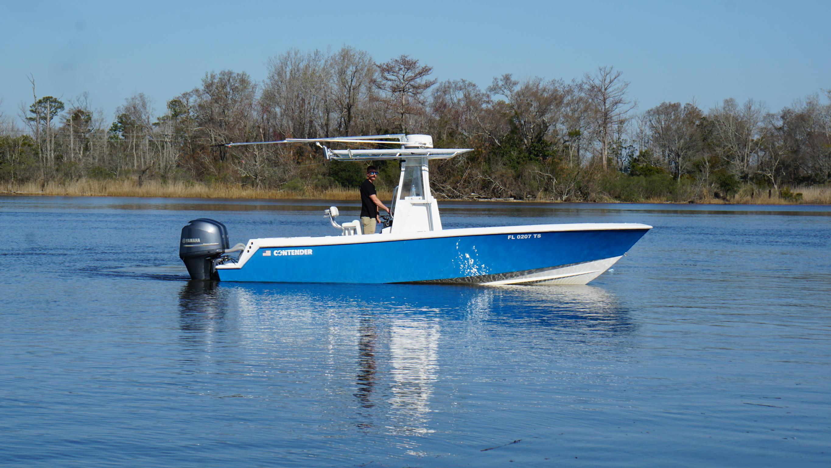 2015 Contender 25 Tournament boat on calm water, with trees in the background.