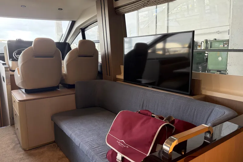 Fire Sale! Yacht Photos Pics Interior of 2020 Azimut 55 yacht with seating, TV, and helm chairs.