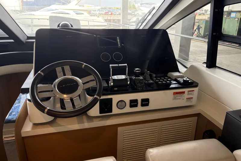 Fire Sale! Yacht Photos Pics Cockpit of 2020 Azimut 55 yacht with steering wheel and control panel.