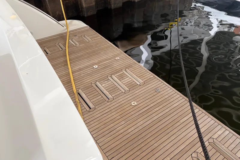 Fire Sale! Yacht Photos Pics Teak deck of 2020 Azimut 55 yacht with mooring lines and water reflection.