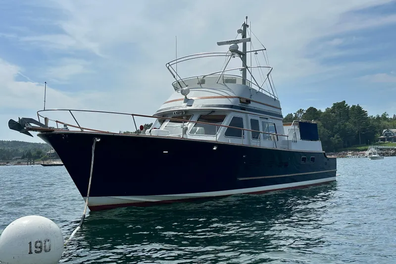  Yacht Photos Pics 1987 Albin North Sea Trawler anchored in scenic waters, surrounded by lush greenery.