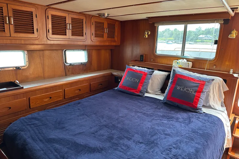  Yacht Photos Pics Cozy cabin interior of 1987 Albin North Sea Trawler with wooden furnishings and comfortable bedding.