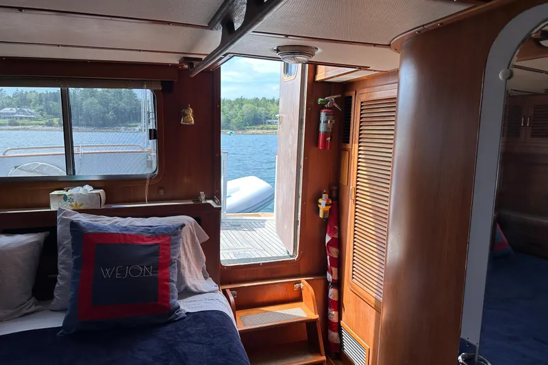  Yacht Photos Pics Cozy cabin interior of 1987 Albin North Sea Trawler with wooden accents and scenic window view.