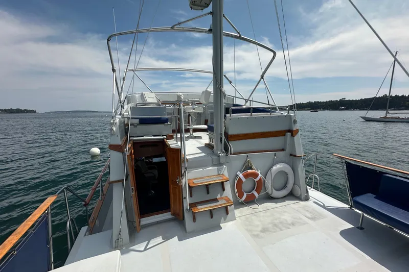  Yacht Photos Pics 1987 Albin North Sea Trawler on calm waters, featuring open deck and safety equipment.