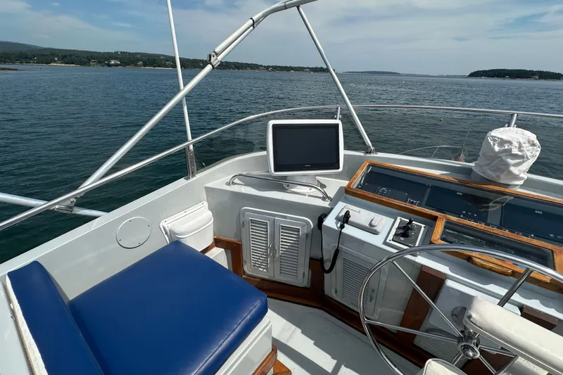  Yacht Photos Pics Helm of 1987 Albin North Sea Trawler with blue seating and navigation equipment.