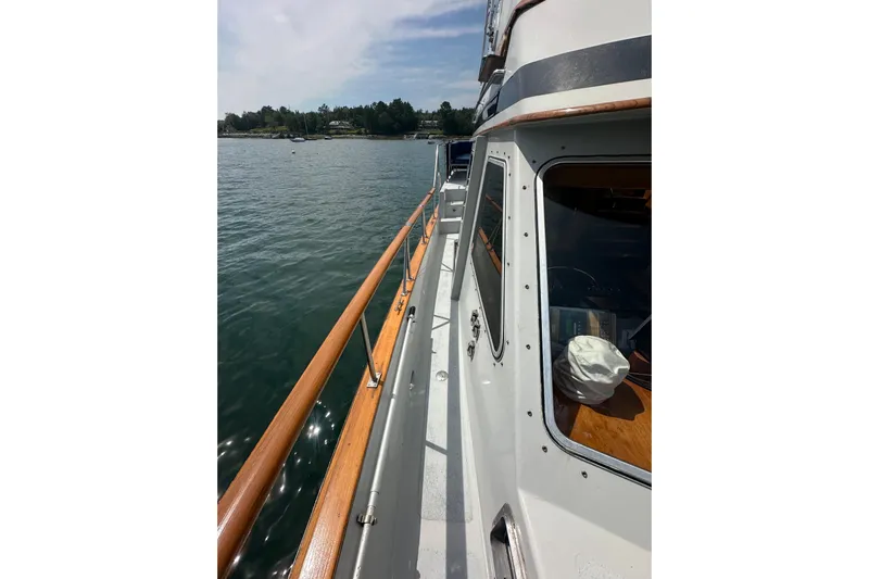  Yacht Photos Pics 1987 Albin North Sea Trawler deck view with wooden railings on calm water.