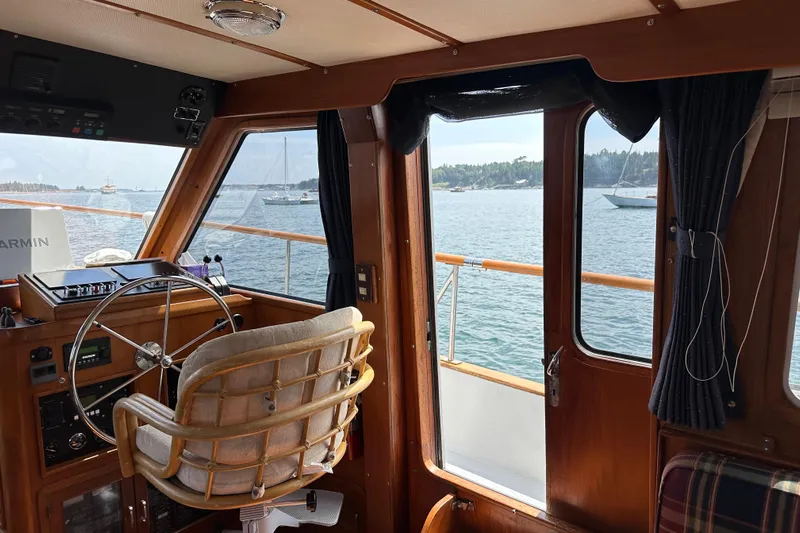  Yacht Photos Pics Interior view of 1987 Albin North Sea Trawler with steering wheel and scenic ocean backdrop.