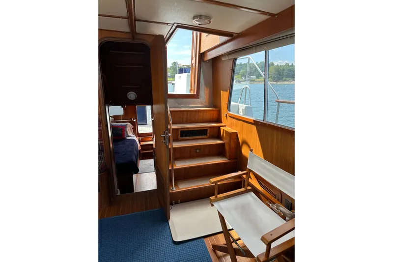  Yacht Photos Pics Interior of 1987 Albin North Sea Trawler with wooden stairs and seating, overlooking water.