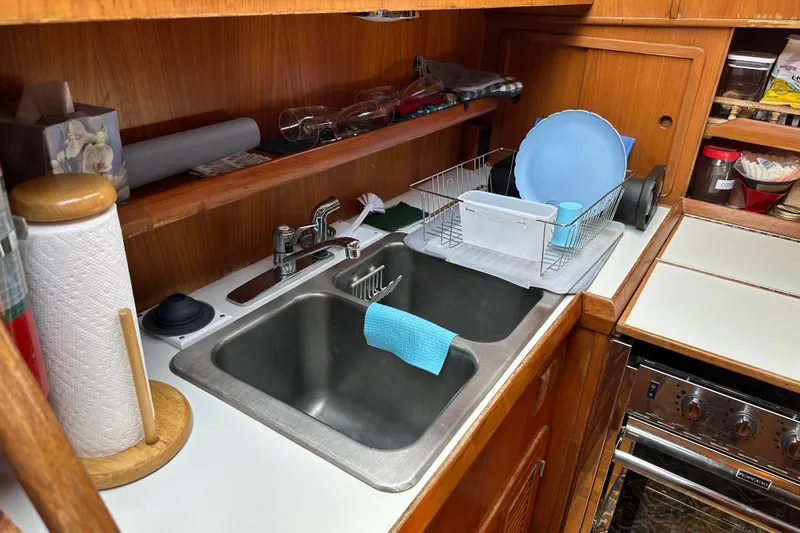  Yacht Photos Pics 1987 Albin North Sea Trawler kitchen with sink, dish rack, and wooden cabinetry.