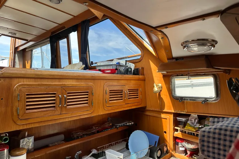  Yacht Photos Pics Interior of 1987 Albin North Sea Trawler with wooden cabinets and nautical decor.