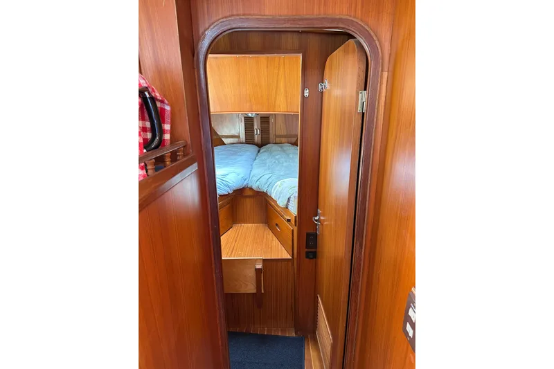  Yacht Photos Pics 1987 Albin North Sea Trawler cabin interior with wooden finish and cozy bedding.