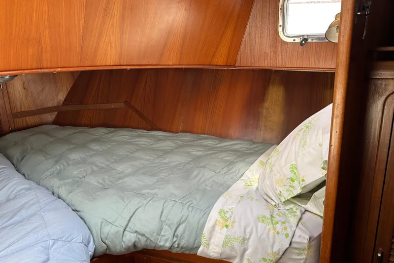  Yacht Photos Pics Cozy cabin bed in 1987 Albin North Sea Trawler with wooden interior.