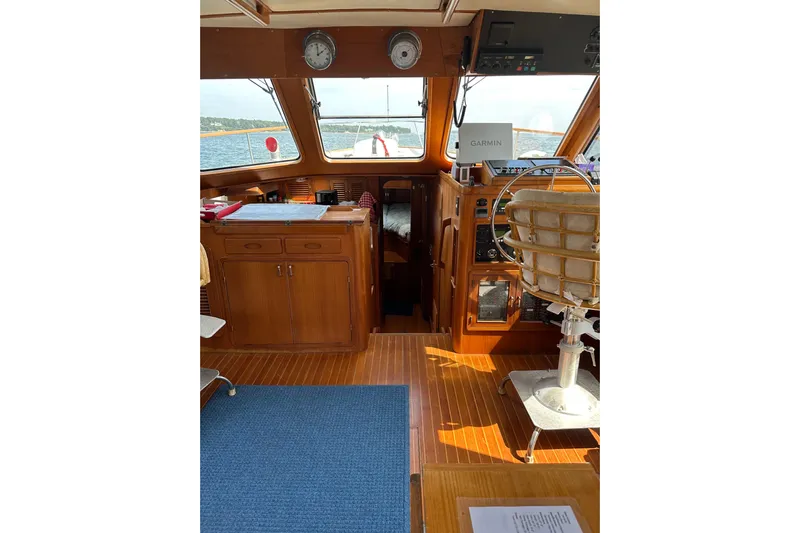 Yacht Photos Pics 1987 Albin North Sea Trawler interior with wooden helm, navigation equipment, and ocean view.