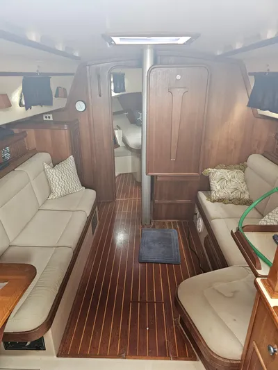 Moon River Yacht Photos Pics Interior of 2002 Island Packet 350 sailboat with wood finish and beige seating.