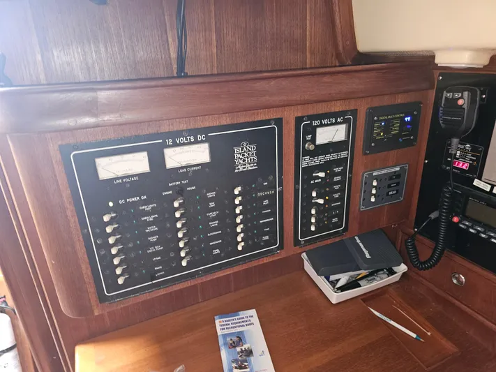 Moon River Yacht Photos Pics Control panel of a 2002 Island Packet 350 sailboat, featuring electrical switches and navigation equipment.