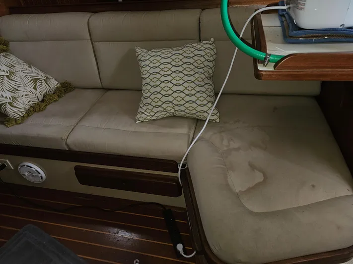 Moon River Yacht Photos Pics Cozy interior of 2002 Island Packet 350 sailboat with cushioned seating and decorative pillows.