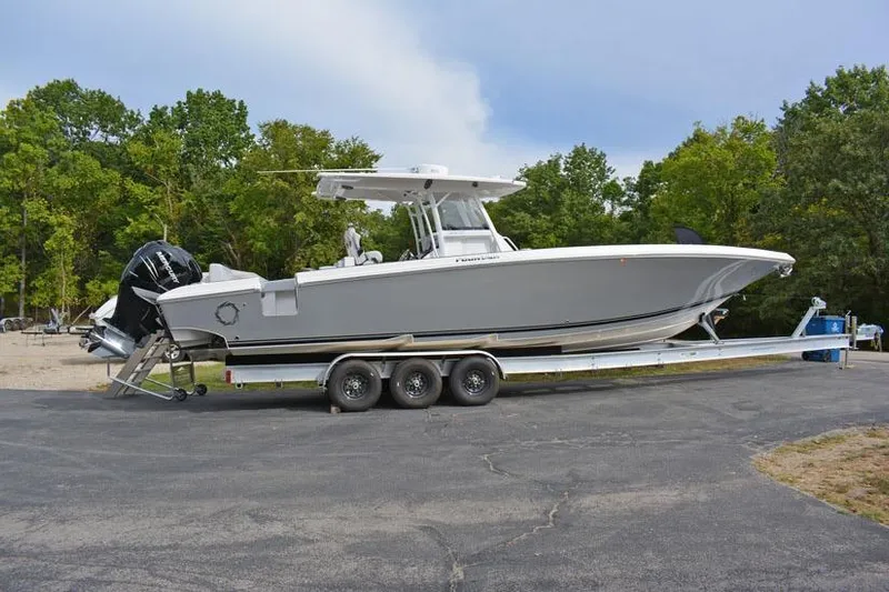  Yacht Photos Pics 2018 Fountain 38 CC boat on trailer, parked outdoors with trees in background.