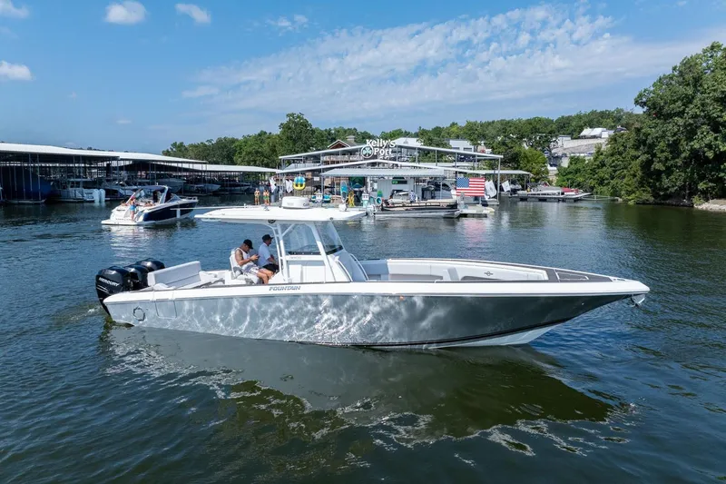  Yacht Photos Pics 2018 Fountain 38 SCX boat cruising on a sunny lake near a marina.