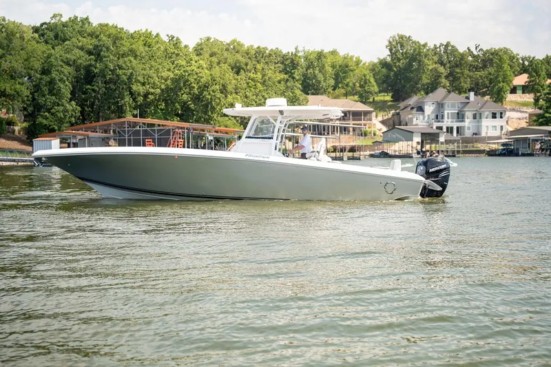  Yacht Photos Pics 2018 Fountain 38 SCX boat on a lake with waterfront homes in the background.