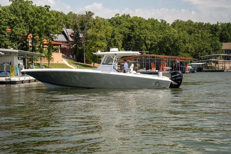  Yacht Photos Pics 2018 Fountain 38 SCX boat on a lake near docks and trees.