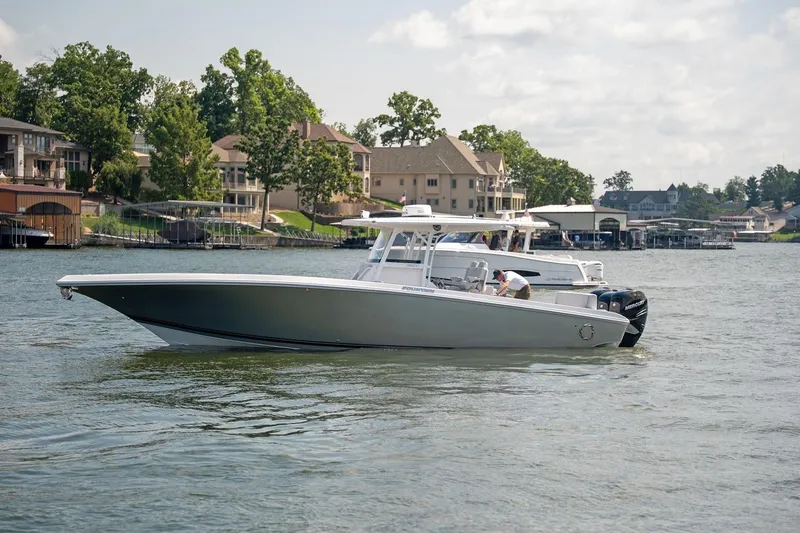  Yacht Photos Pics 2018 Fountain 38 SCX boat on a lake near waterfront homes.