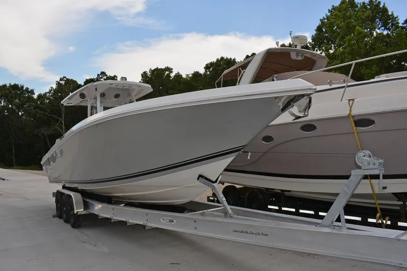  Yacht Photos Pics 2018 Fountain 38 SCX boat on trailer, parked beside another boat, outdoors.