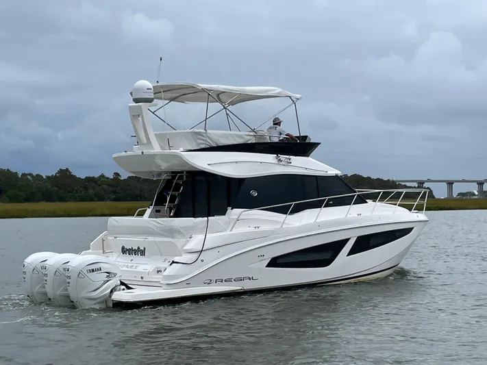 Grateful Yacht Photos Pics 2022 Regal 42 FXO yacht cruising on a calm river with overcast skies.