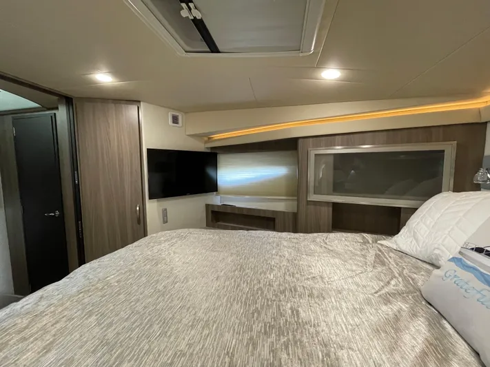 Grateful Yacht Photos Pics Luxurious interior of 2022 Regal 42 FXO yacht with modern amenities and cozy bedding.