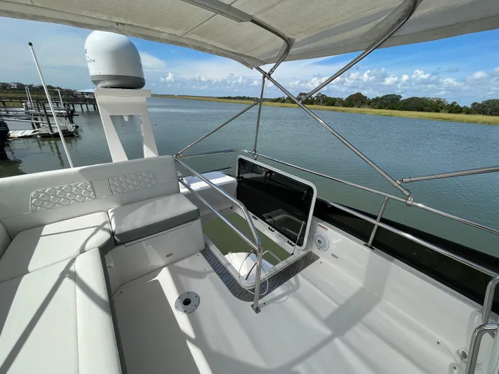 Grateful Yacht Photos Pics 2022 Regal 42 FXO yacht interior with seating, overlooking serene waterway.