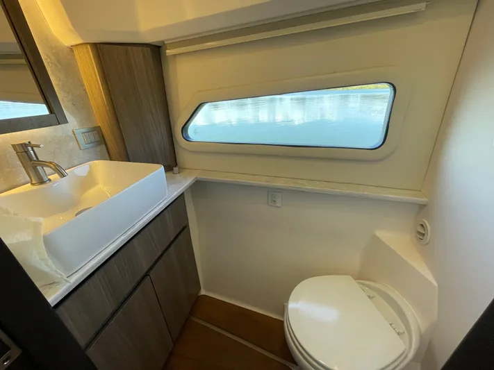 Grateful Yacht Photos Pics 2022 Regal 42 FXO yacht bathroom with modern sink, toilet, and window.