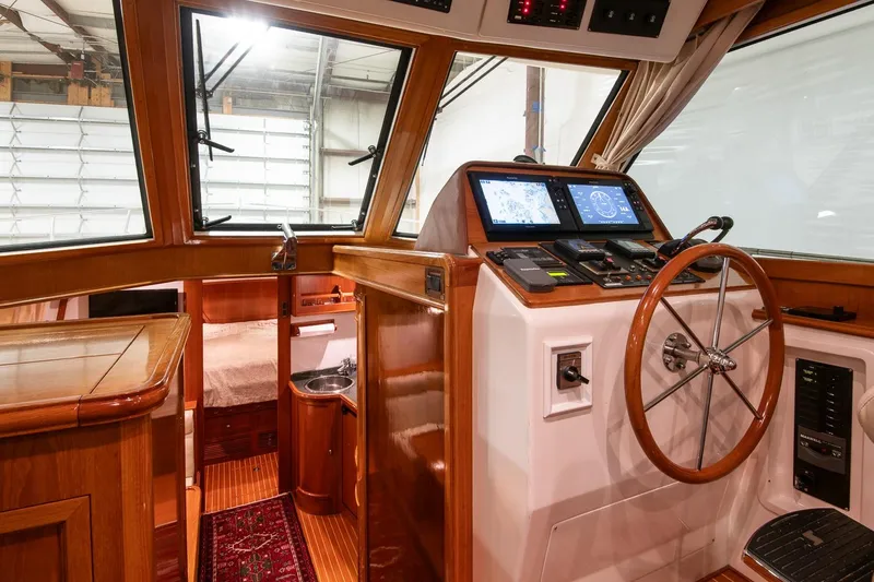 Blue Tang Yacht Photos Pics 2007 Grand Banks 39 Eastbay SX yacht interior with wooden helm, navigation screens, and cozy cabin.