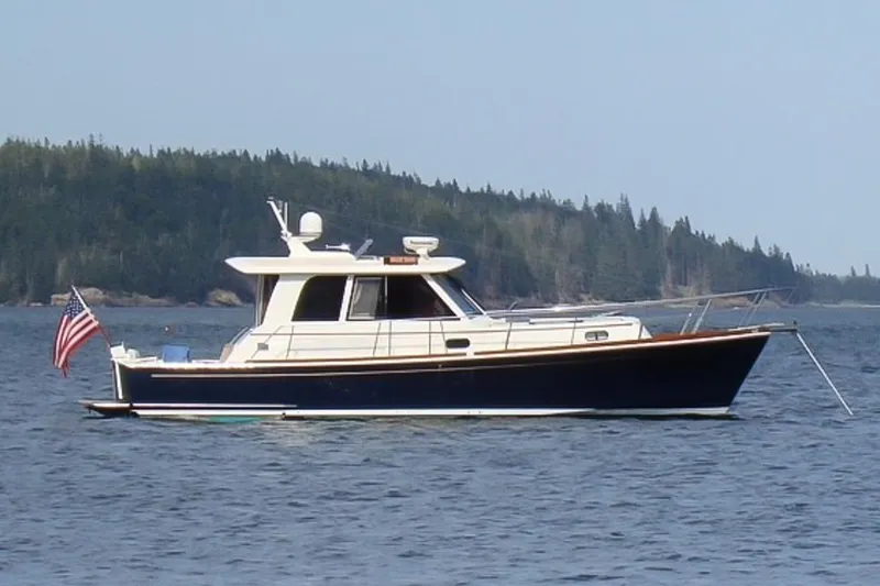 Blue Tang Yacht Photos Pics 2007 Grand Banks 39 Eastbay SX yacht on calm water with forested shoreline.