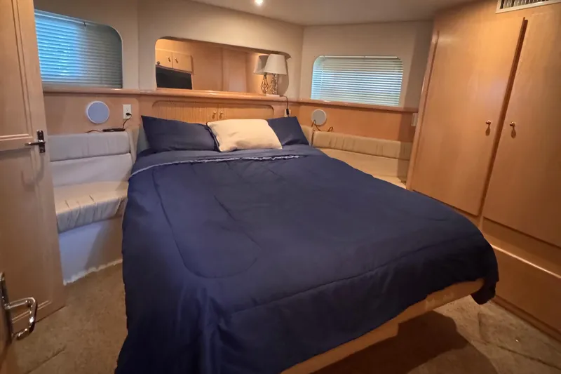  Yacht Photos Pics 1998 Carver 405 Aft Cabin bedroom with blue bedding and wooden interior.