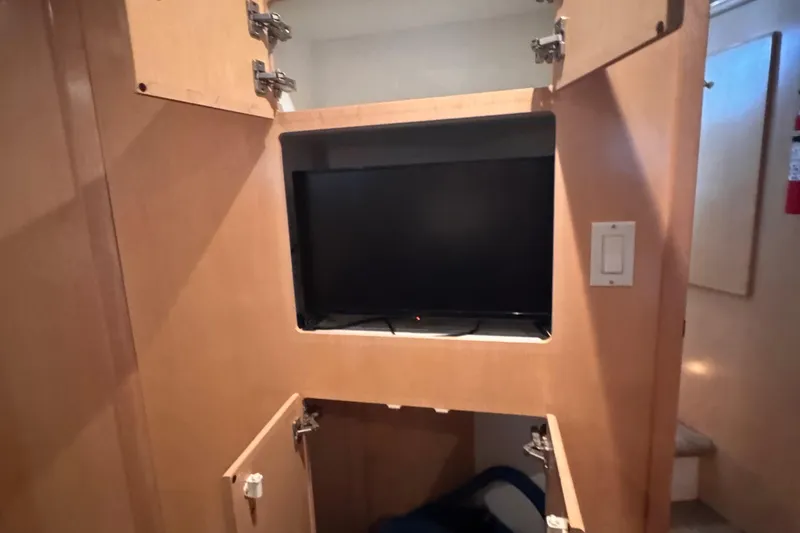  Yacht Photos Pics 1998 Carver 405 Aft Cabin interior with built-in TV and open wooden cabinets.