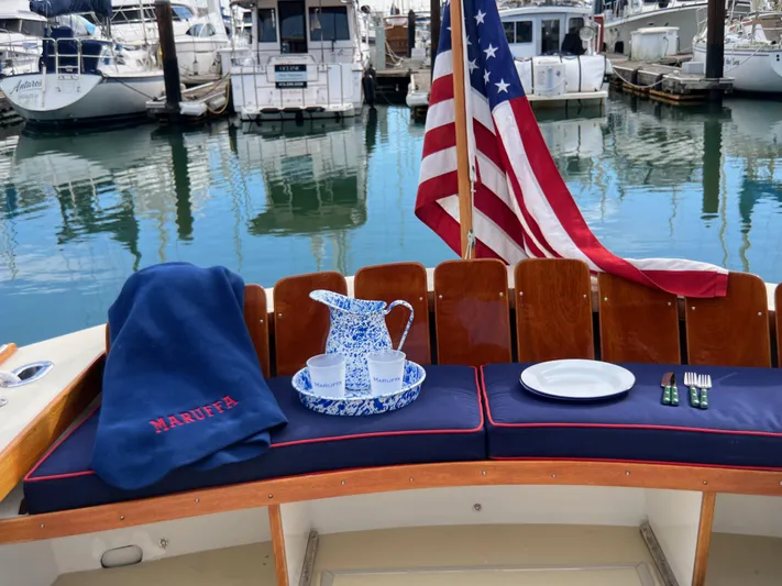 Maruffa Yacht Photos Pics 1980 Dyer 29 boat with American flag, marina view, and nautical-themed table setting.