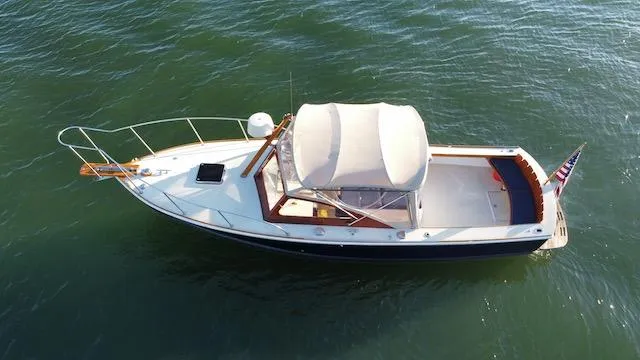 Maruffa Yacht Photos Pics 1980 Dyer 29 boat with canopy, cruising on calm green waters.