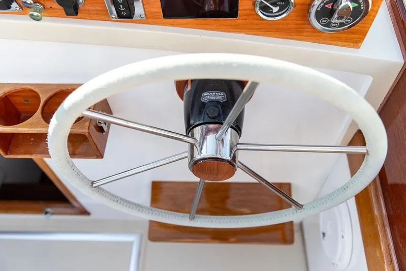 Maruffa Yacht Photos Pics Steering wheel of a 1980 Dyer 29 boat, featuring a classic wooden dashboard.
