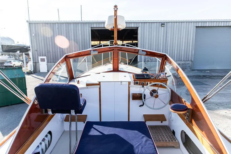 Maruffa Yacht Photos Pics 1980 Dyer 29 boat interior with wooden trim and blue seating, docked near a warehouse.