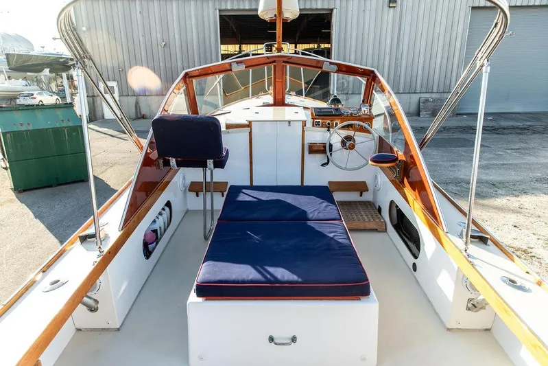 Maruffa Yacht Photos Pics 1980 Dyer 29 boat interior with blue cushions, wooden accents, and steering wheel in a marina setting.