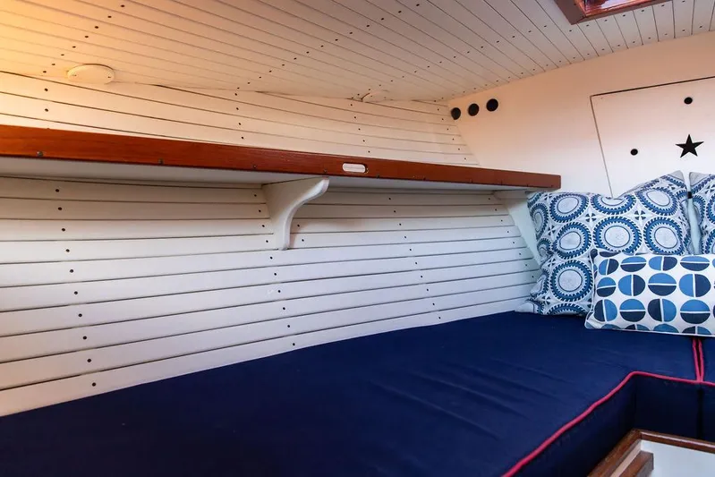 Maruffa Yacht Photos Pics Cozy cabin interior of 1980 Dyer 29 boat with blue cushions and patterned pillows.