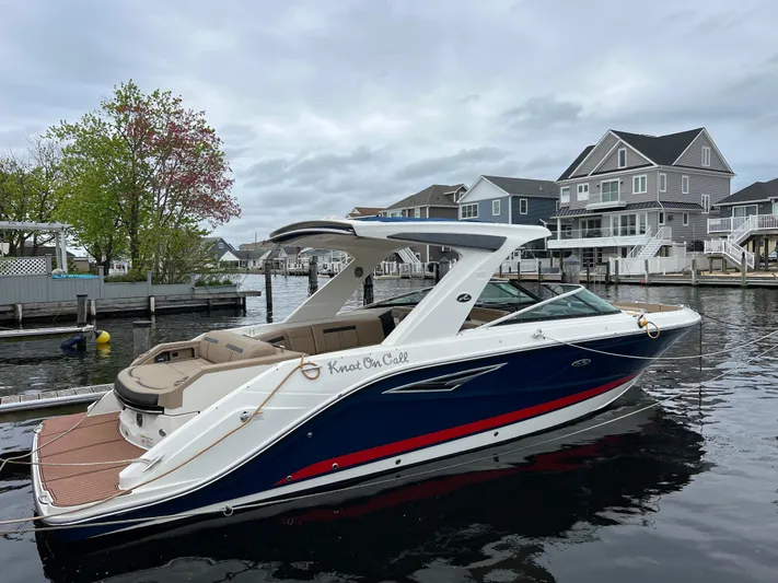 Knot On Call Yacht Photos Pics 2018 Sea Ray 310 SLX boat docked by waterfront homes, overcast sky.