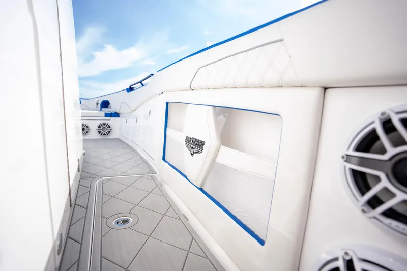  Yacht Photos Pics 2024 Deep Impact 399 Sport boat interior with sleek white and blue design, featuring modern speakers.