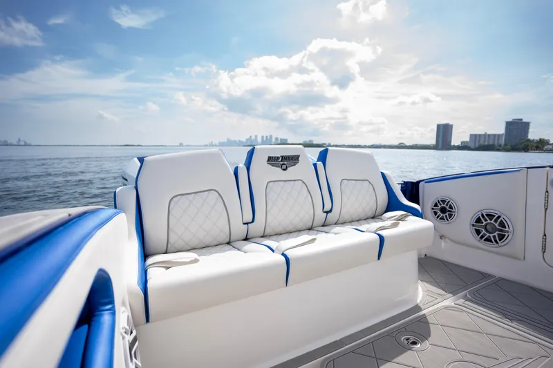  Yacht Photos Pics 2024 Deep Impact 399 Sport boat interior with white and blue seating, ocean view.