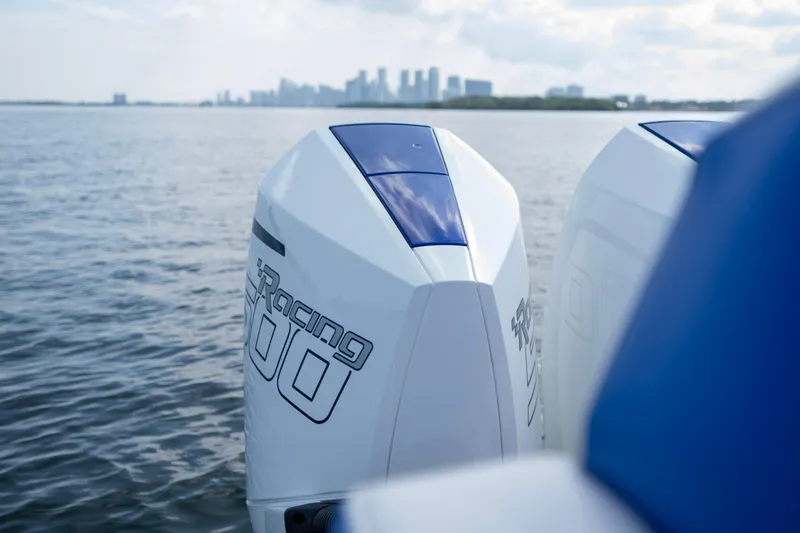  Yacht Photos Pics 2024 Deep Impact 399 Sport boat engines on water with city skyline in background.