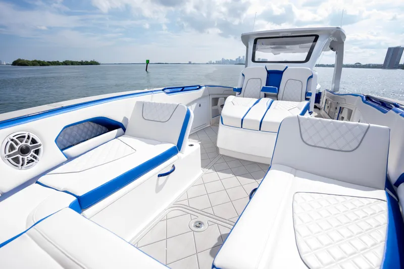  Yacht Photos Pics 2024 Deep Impact 399 Sport boat interior with white and blue seating on open water.