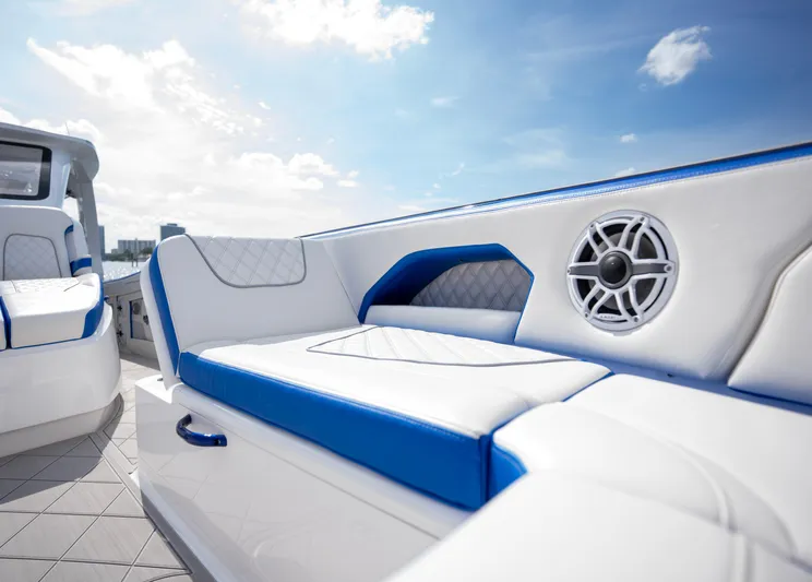  Yacht Photos Pics 2024 Deep Impact 399 Sport boat interior with blue and white seating and speaker system.