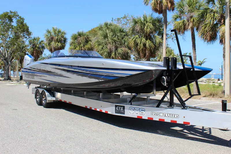 Yacht Photos Pics 2025 Fountain 34 Thundercat boat on trailer, parked near palm trees.