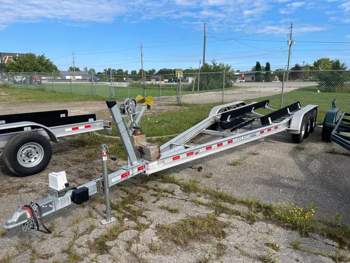  Yacht Photos Pics Boat trailer for 2022 Sea Ray SLX 280, parked on gravel with blue sky background.