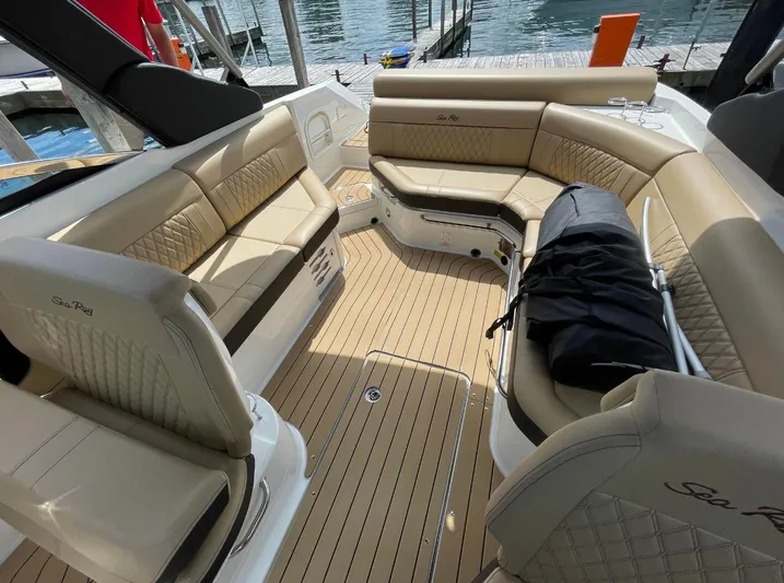  Yacht Photos Pics Luxurious interior of 2022 Sea Ray SLX 280 boat with beige seating and wood flooring.