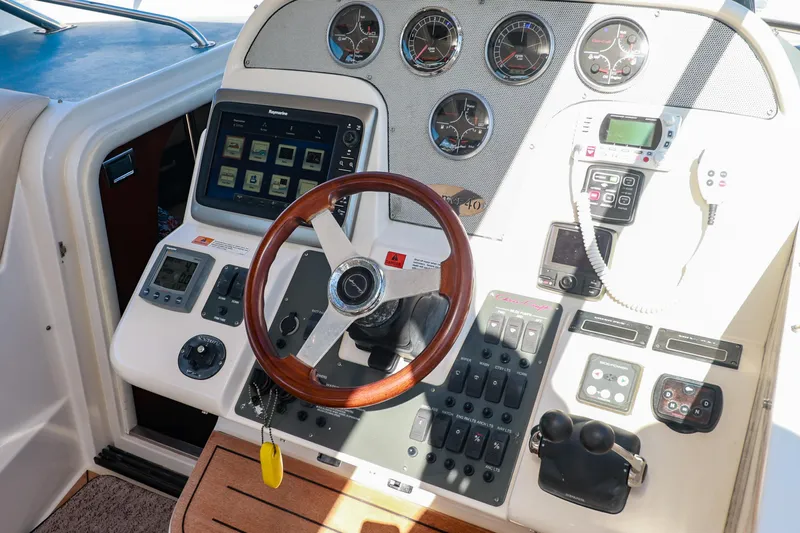 Aphrodite Yacht Photos Pics 2004 Chris-Craft Roamer 40 helm with wooden steering wheel and modern navigation controls.